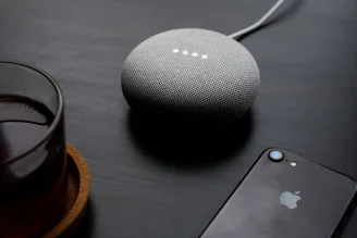 google home mini on a table with iPhone 7