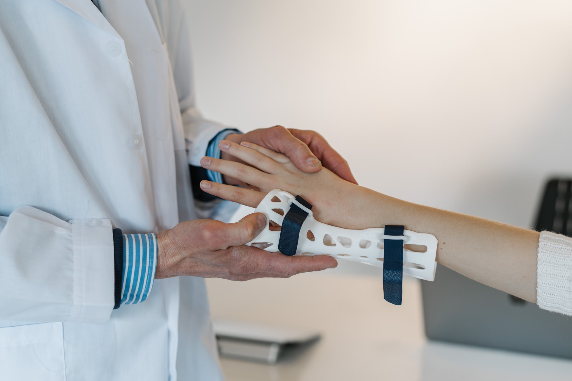 A Doctor Putting Support On A Female'S Arm