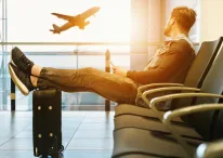 A person sitting on an AirPort to travel along with his luggage
