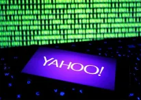 Yahoo logo opened in a smartphone in front of a computer screen