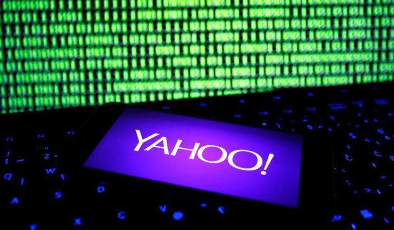 Yahoo logo opened in a smartphone in front of a computer screen