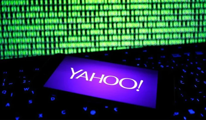 Yahoo logo opened in a smartphone in front of a computer screen