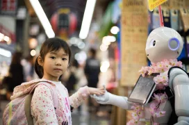A photo of a child shaking hand with a robot