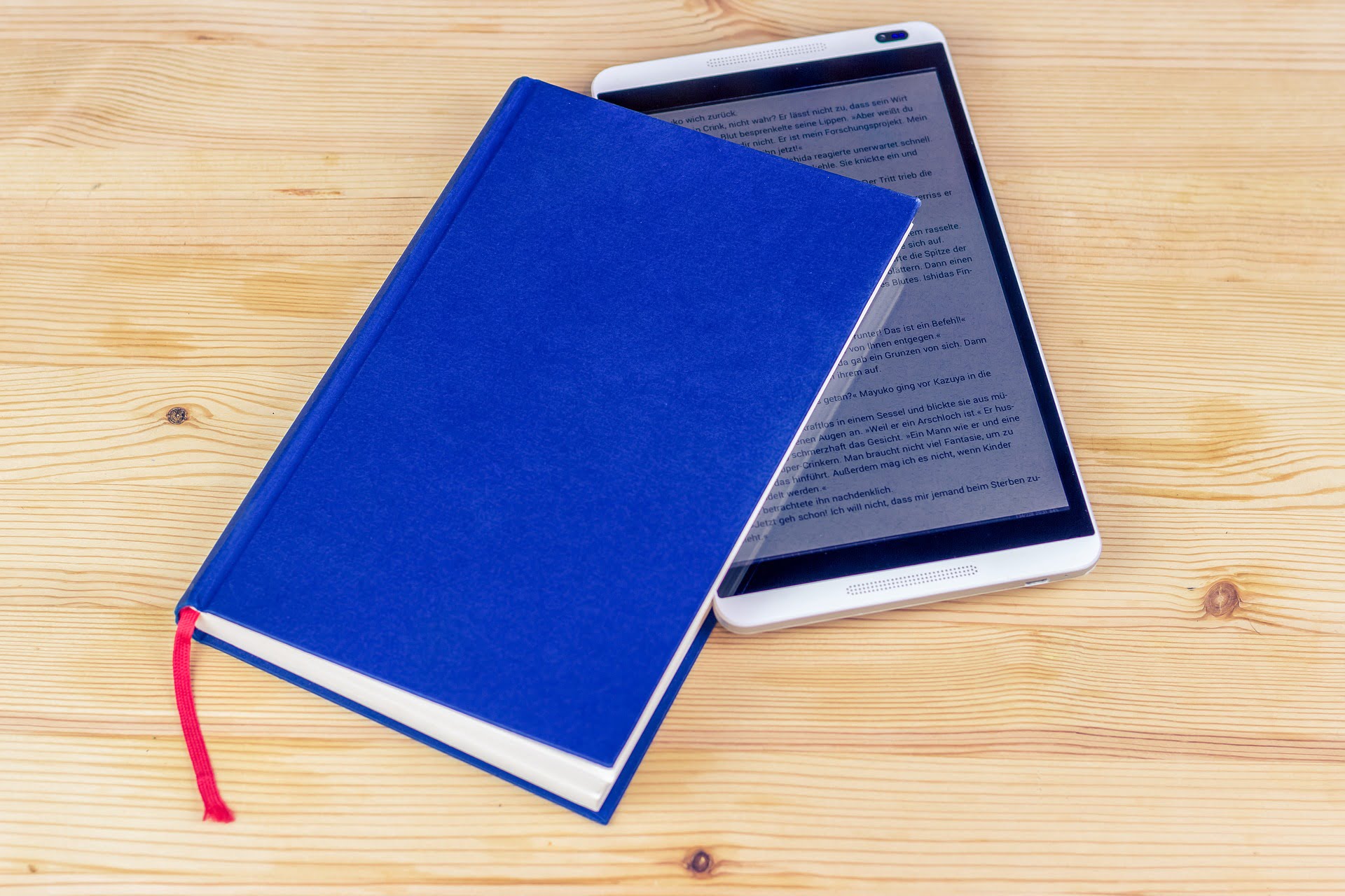 5 Uses For Old Android And Ios Devices 1 - Techengage A Photo Of The Tablet With An Ebook Opened, Placed Inside A Blue Book