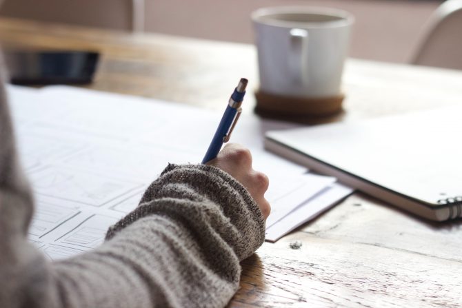 A photo of a person writing on a paper