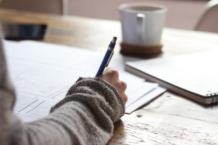 A photo of a person writing on a paper