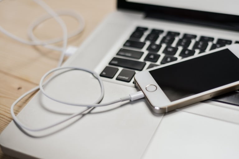 A photo of iPhone plugged in to a MacBook