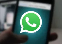 A photo of WhatsApp running on a phone in the background, a featured image for WhatsApp Beta gets forward counter with WhatsApp icon