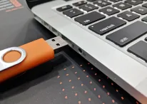 A photo of a USB about to plug in the laptop