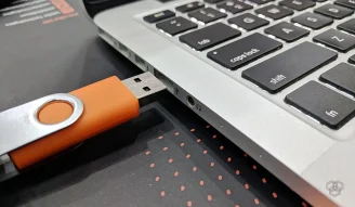A photo of a USB about to plug in the laptop