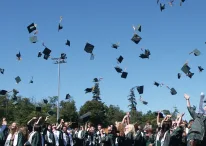 high school students tossing their graduation hats in the air