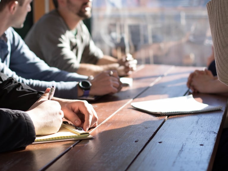 A photo of people sitting on a table discussing