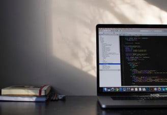 A photo of MacBook Pro with some books placed near it