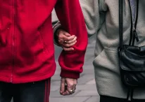 A photo of two couples holding arms in public