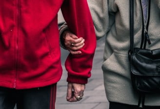 A photo of two couples holding arms in public