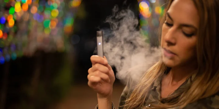 A girl smoking using a vaping device