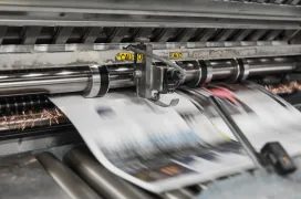 A photo of Newspaper machine printing out Newspapers