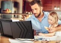 A person sitting at a table in front of a computer Description automatically generated