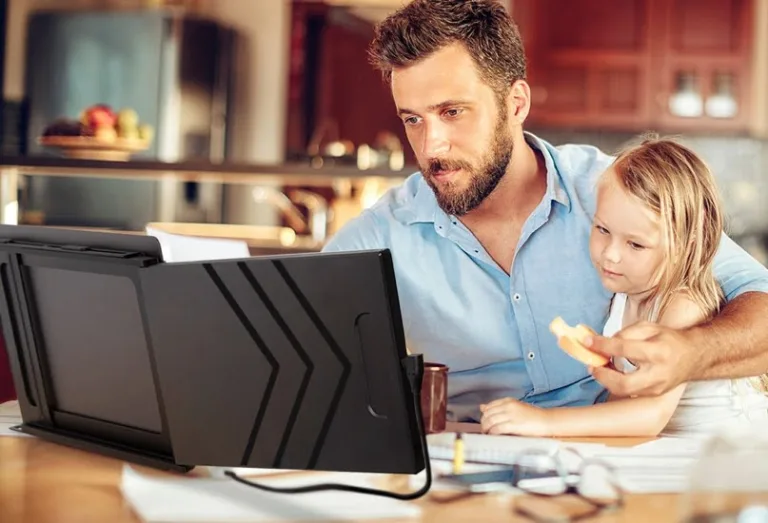 A person sitting at a table in front of a computer Description automatically generated