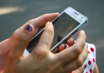 Human hand holding white Samsung Galaxy Duos Android Smartphone