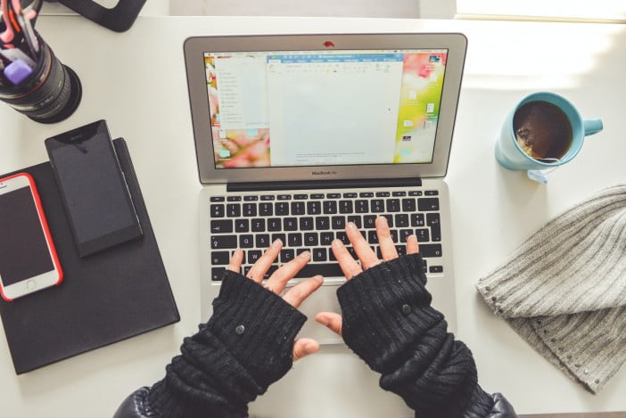 A Girl Typing On A Laptop