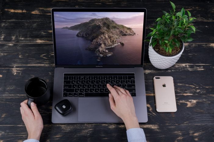 A Person Using Laptop Along With Redux Headphones