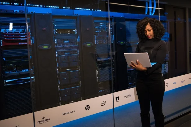 A girl using laptop near servers