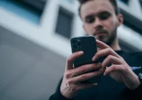 A photo of a man using his iPhone